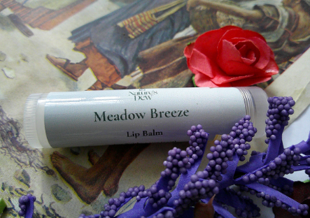 Meadow Breeze Lip Balm with floral and soothing essence, displayed with decorative flowers.