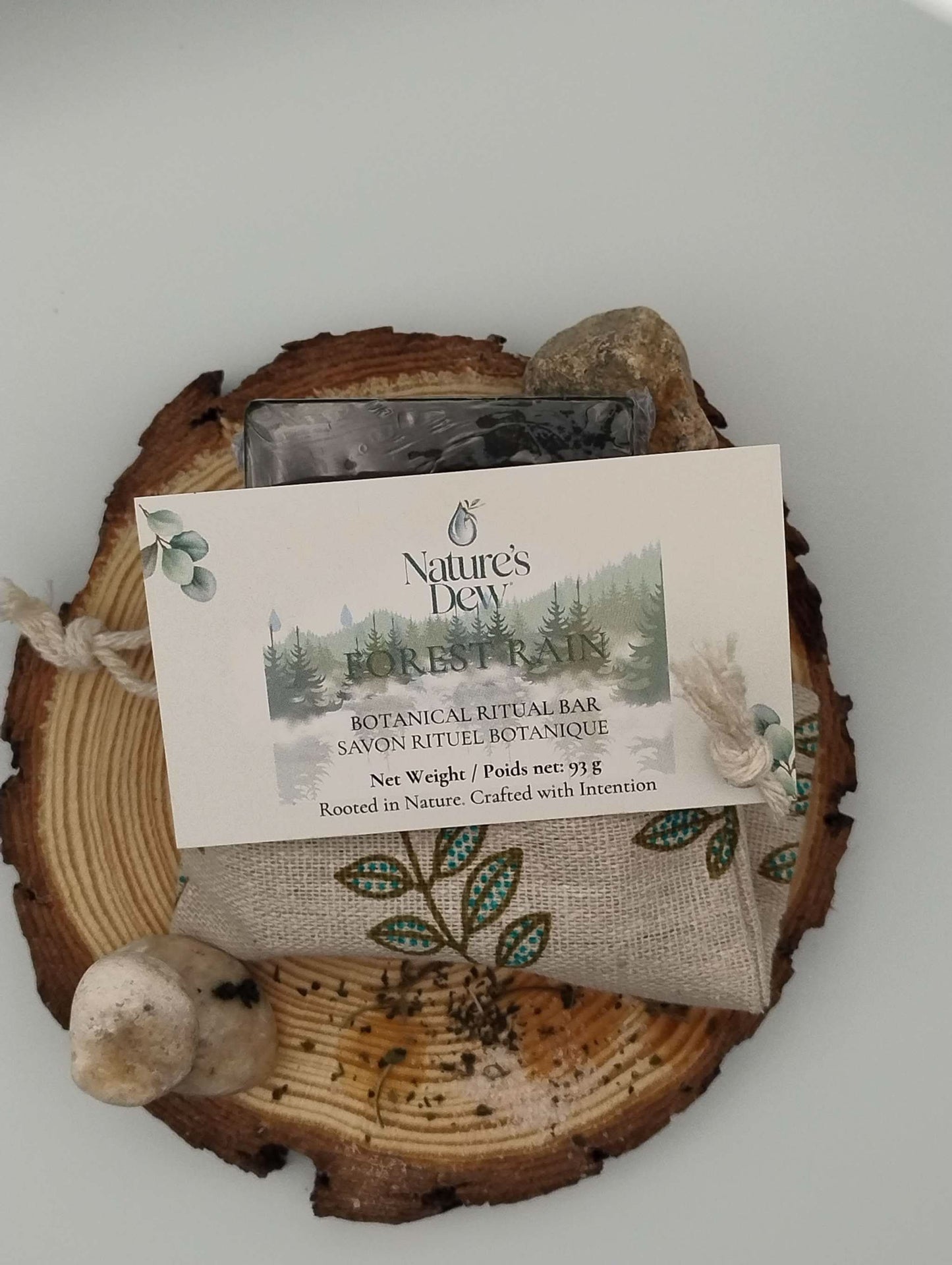 Forest Rain Ritual Soap Bar with natural ingredients and rustic packaging on a wooden base.