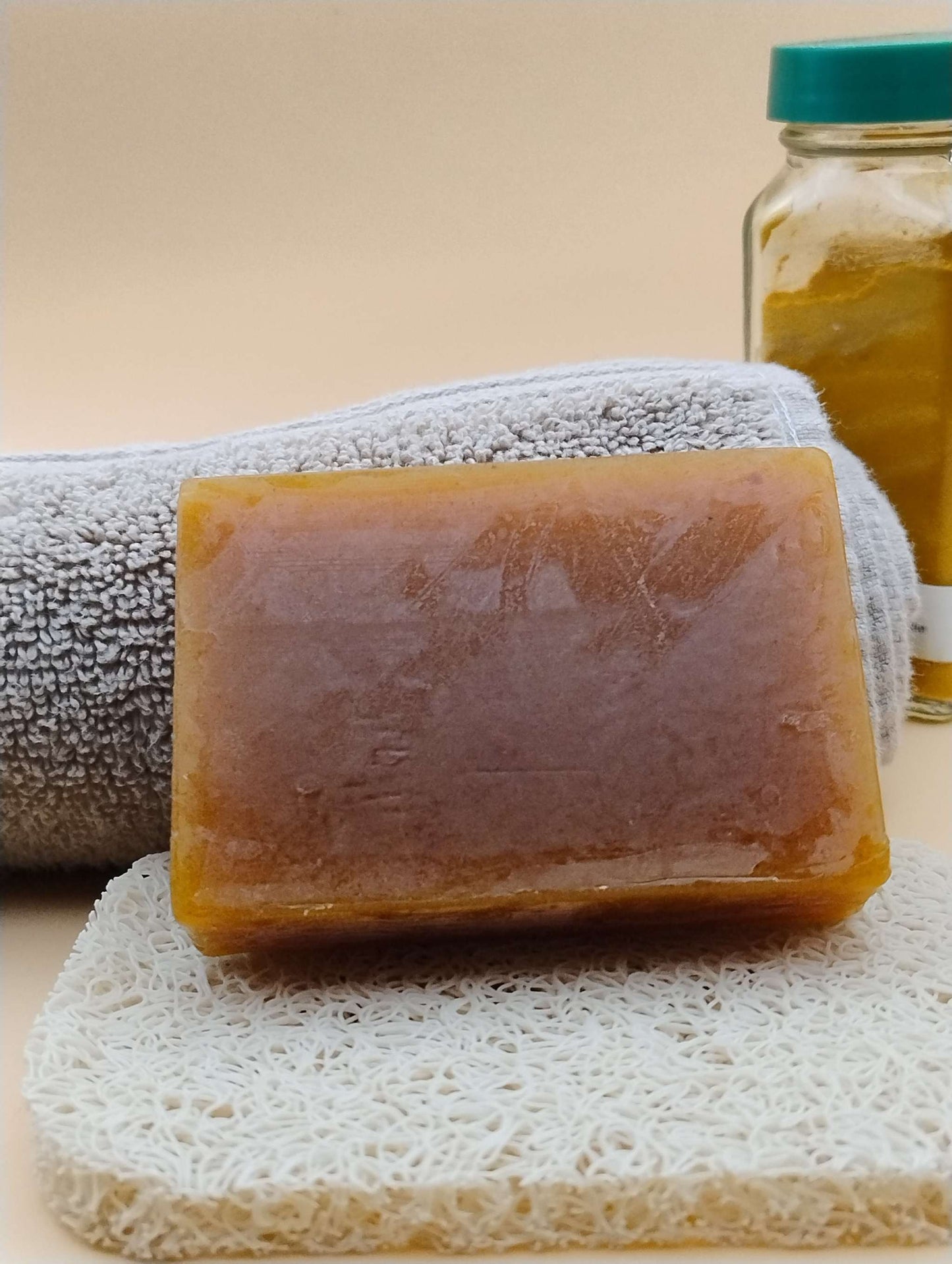Golden Dawn Ritual Soap Bar with bright citrus and spice aroma, displayed on a textured soap mat with a towel and jar in the background.