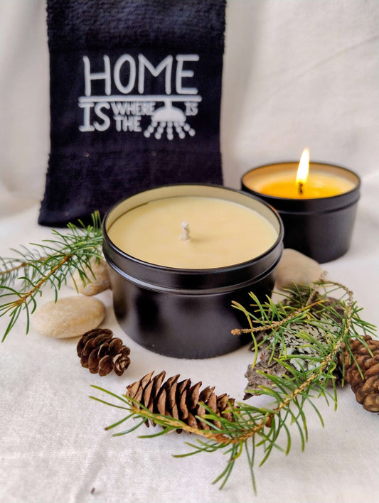 Forest Rain Candle in black tins with pinecones and evergreen sprigs, evoking a fresh, earthy forest scent after rain